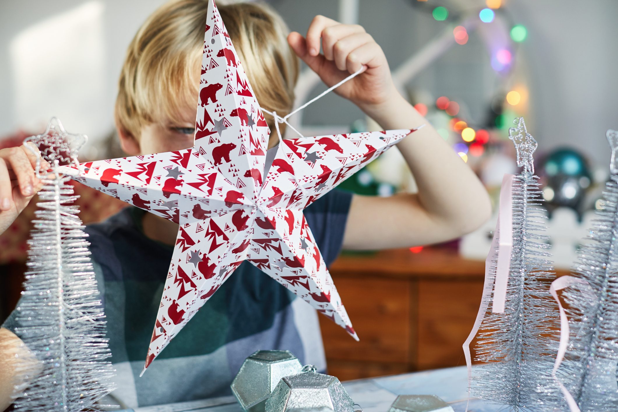 Child holding up a star Christmas decoration