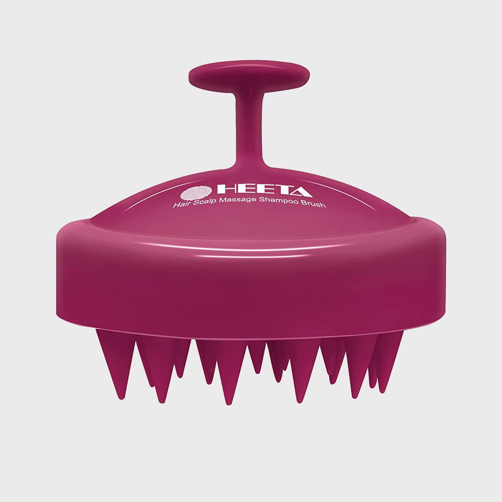 A pink scalp massage brush with a handle rests on a flat surface. Text reads: "HEETA Hair Scalp Massage Shampoo Brush."