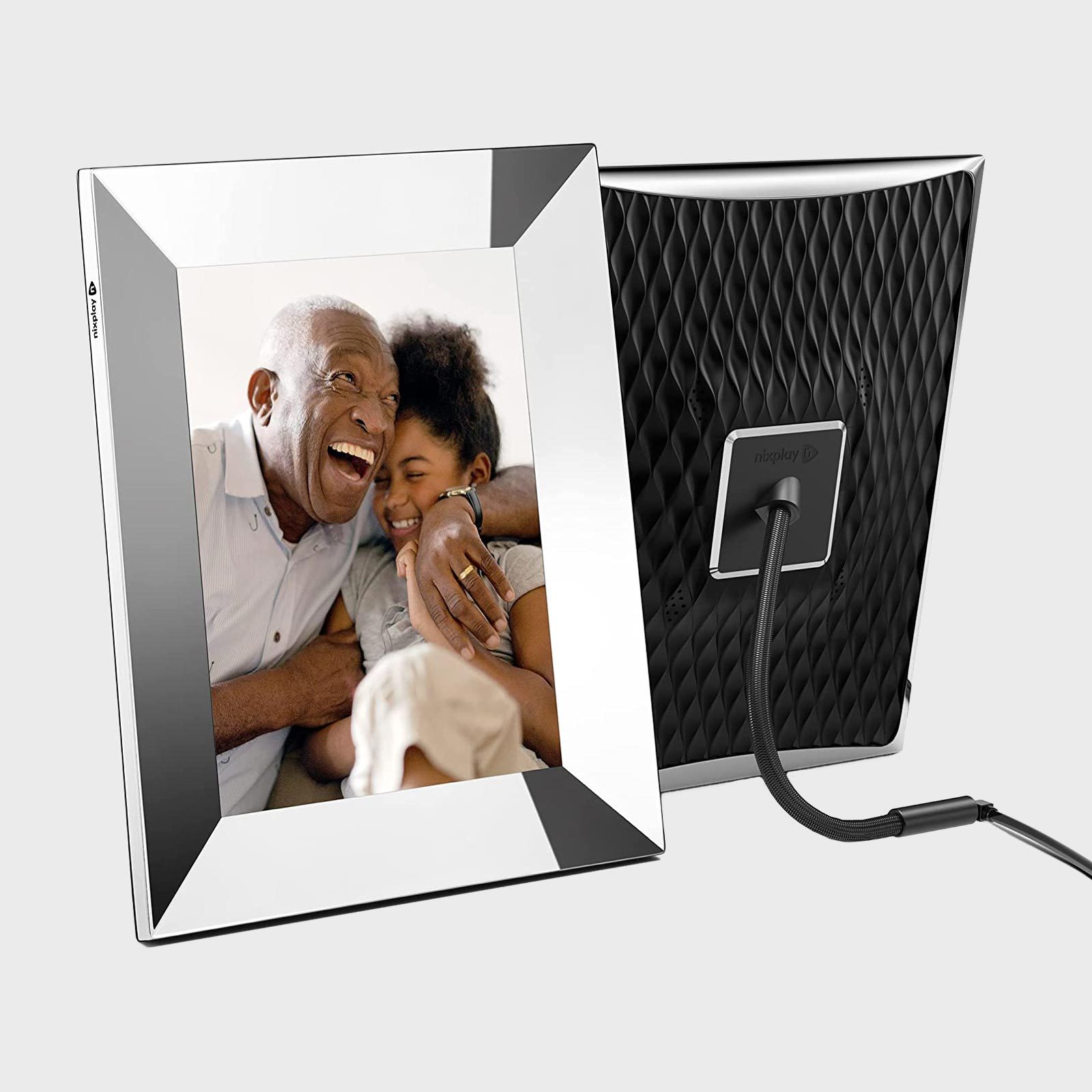 Digital photo frame displays a joyful elderly man embracing a child, positioned on a stand with a textured black back panel.