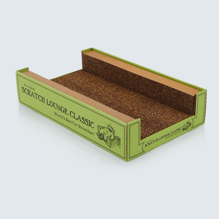 Cat scratcher resting on a flat surface, surrounded by green cardboard packaging with text: 