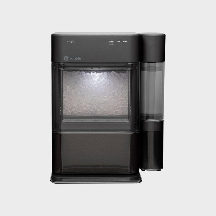 Ice machine producing nugget ice, housed in a black rectangular frame, featuring control buttons; set against a plain gray background.