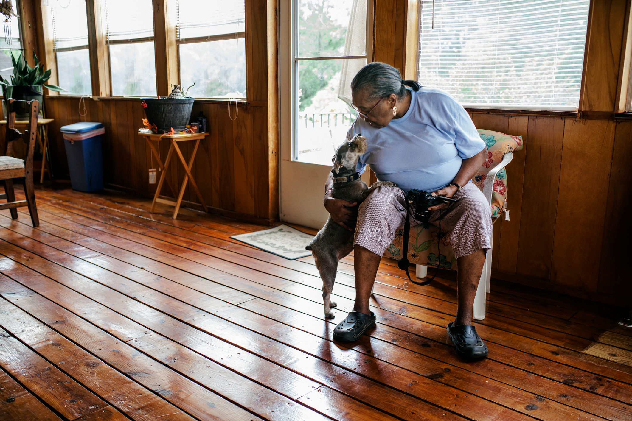 Senior black woman patting the family dog