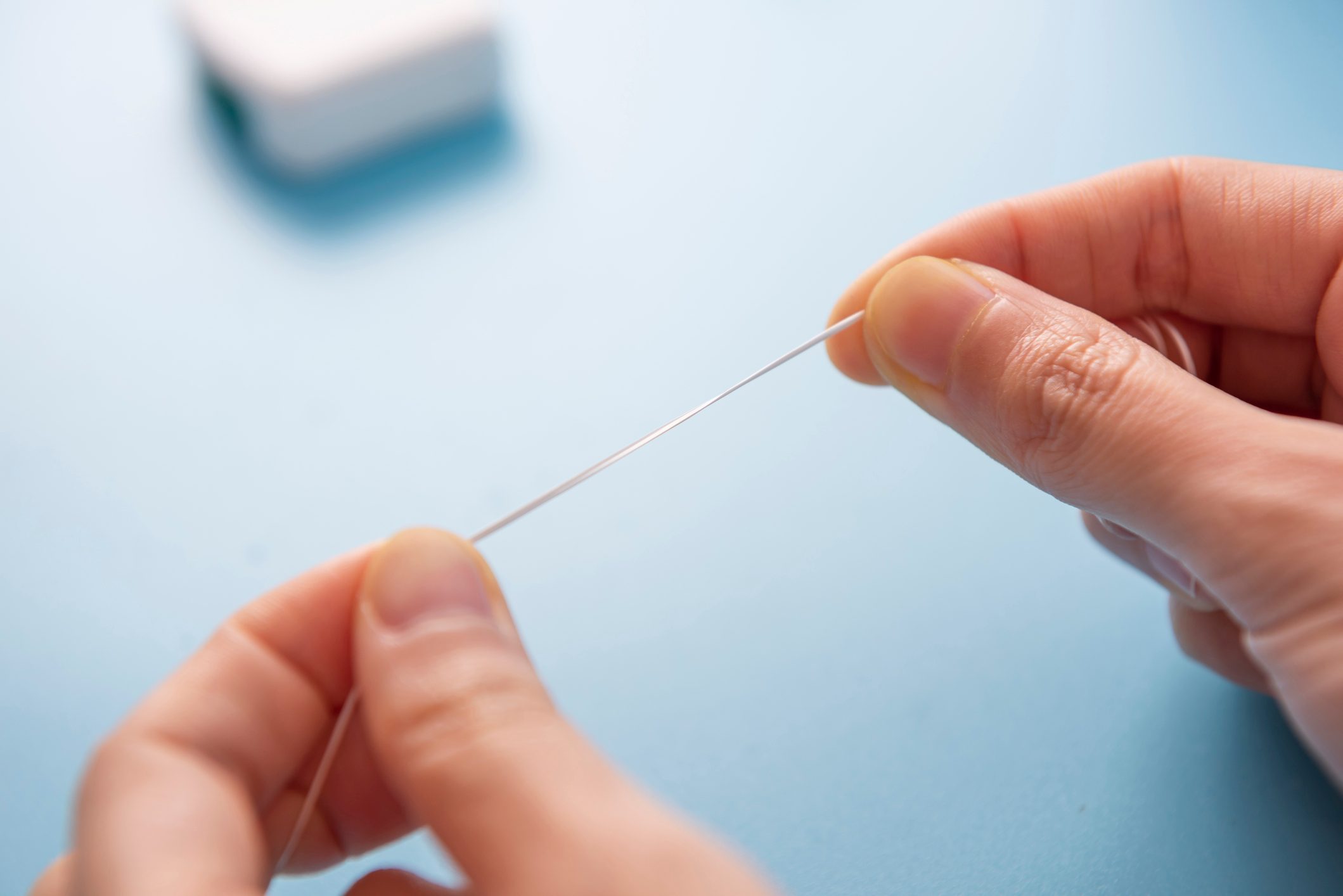 Dental health concept. Woman's hand holding dental floss，and teeth cleaning tools background