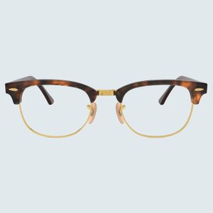Classic tortoiseshell eyeglasses rest stationary, featuring gold metal rims and nose pads, set against a light blue background.