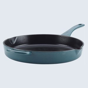 A turquoise cast iron skillet with two handles sits on a light gray surface.