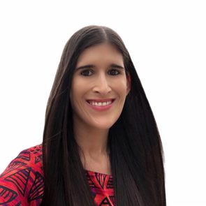 A person smiles, wearing a red patterned top, with long dark hair, against a plain white background.