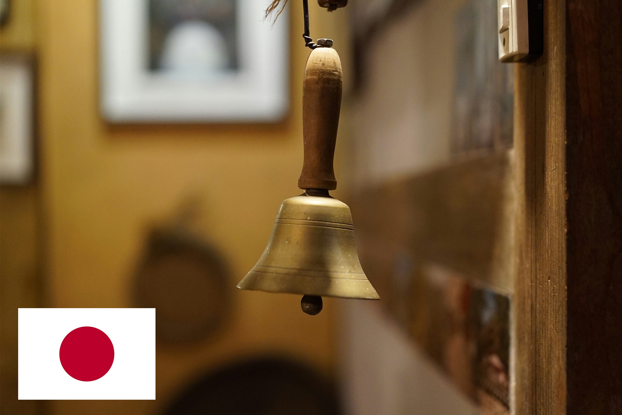 bell hanging near door with japan flag