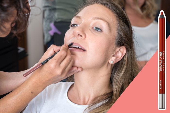 A woman receives lip liner makeup application while seated; a red lip pencil is displayed alongside.