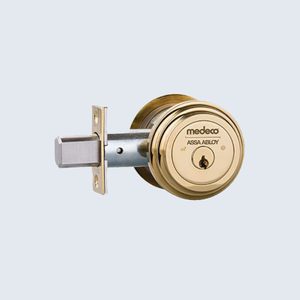 Gold deadbolt lock extended against a light blue background, featuring the brand 