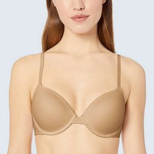 A person wears a beige bra against a plain light background, showing only the upper torso and head.