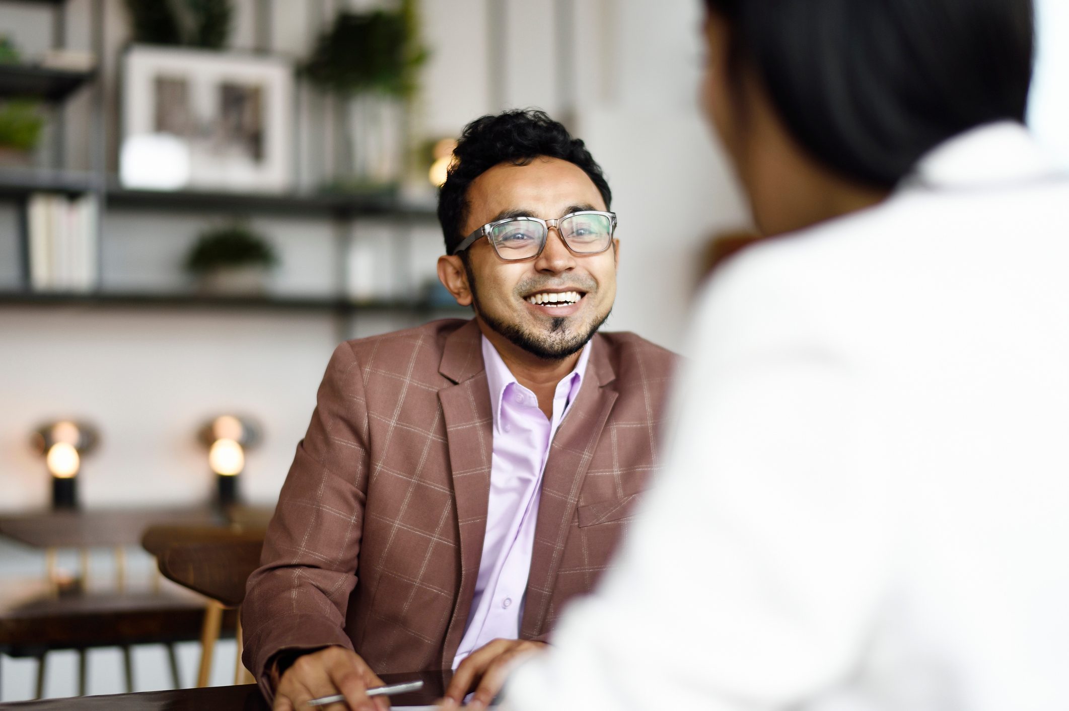 Malay man signing papers at a business meeting