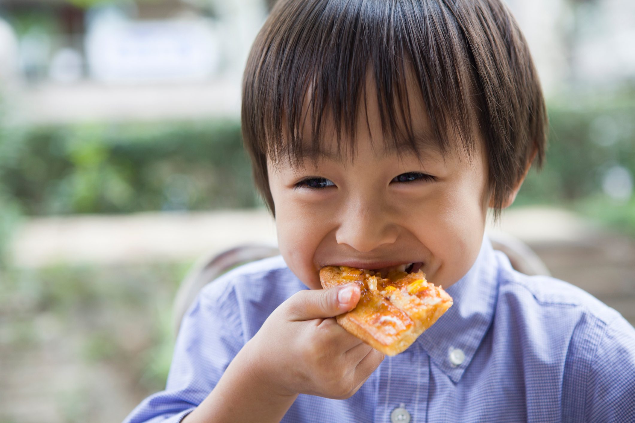 Little boy eating slices of pizza