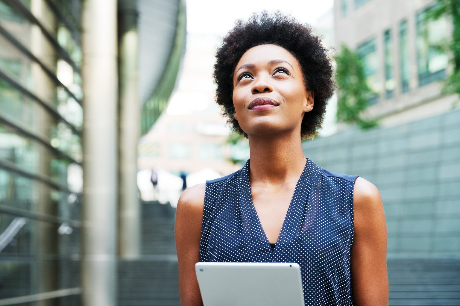 Woman with tablet looking up