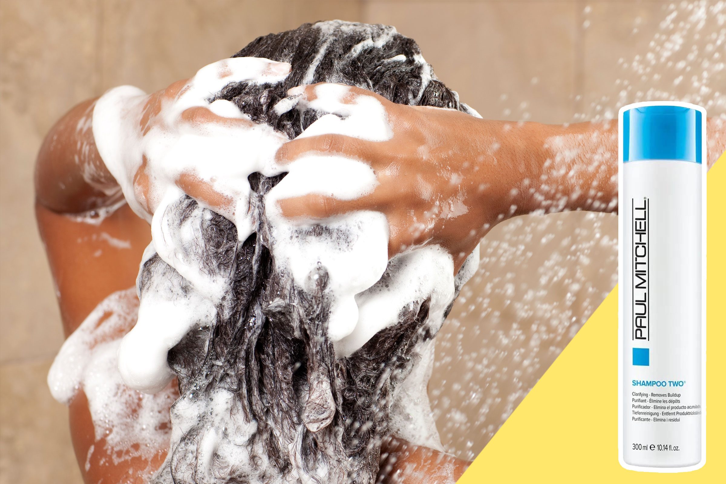 Hands lather hair with shampoo in a shower. A bottle labeled "Paul Mitchell Shampoo Two" appears on the right side.