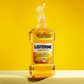 A Listerine bottle splashes liquid in a bright yellow background, highlighting 