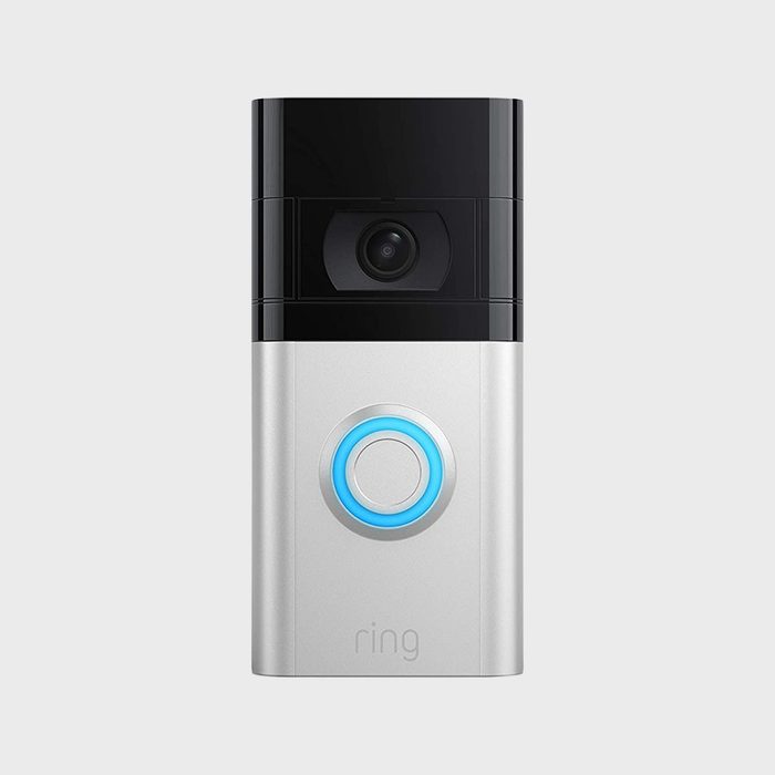 A silver and black video doorbell with a glowing blue ring button; the word 