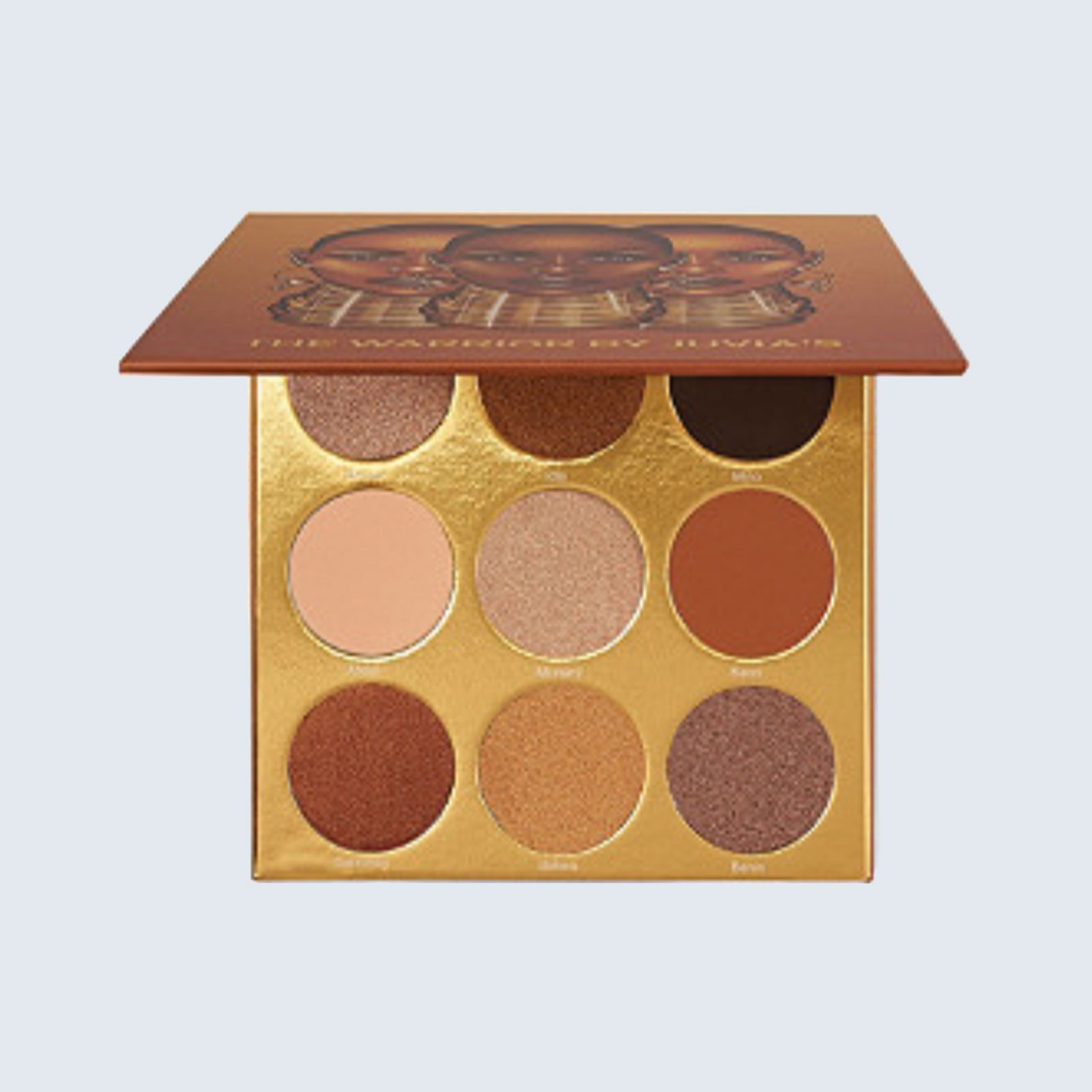 Makeup palette displays nine circular shades on a golden background, beneath a lid showing illustrated faces.