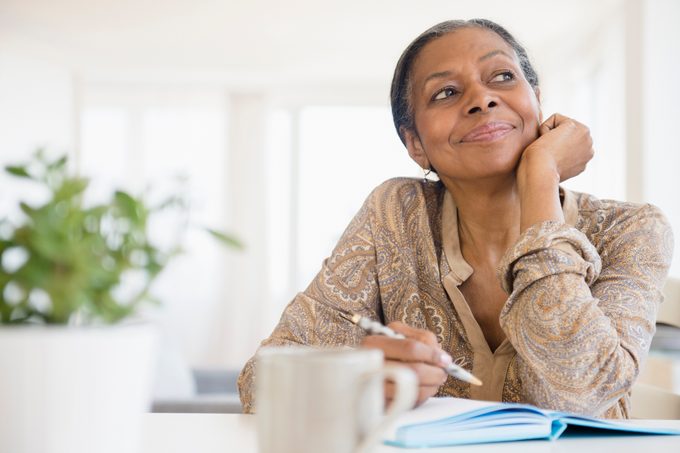 Mixed race woman writing at desk