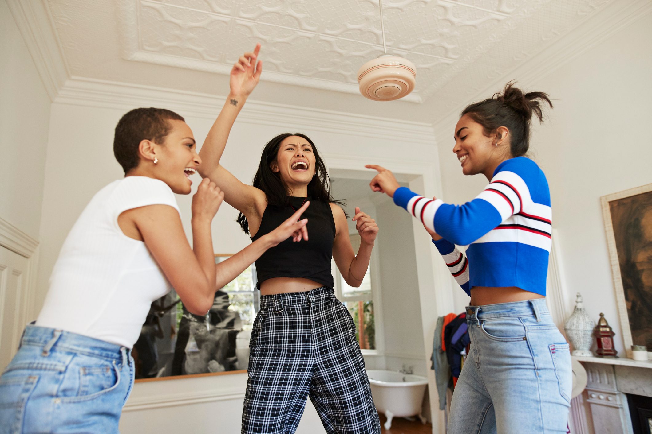 Young friends dancing and enjoying in bedroom