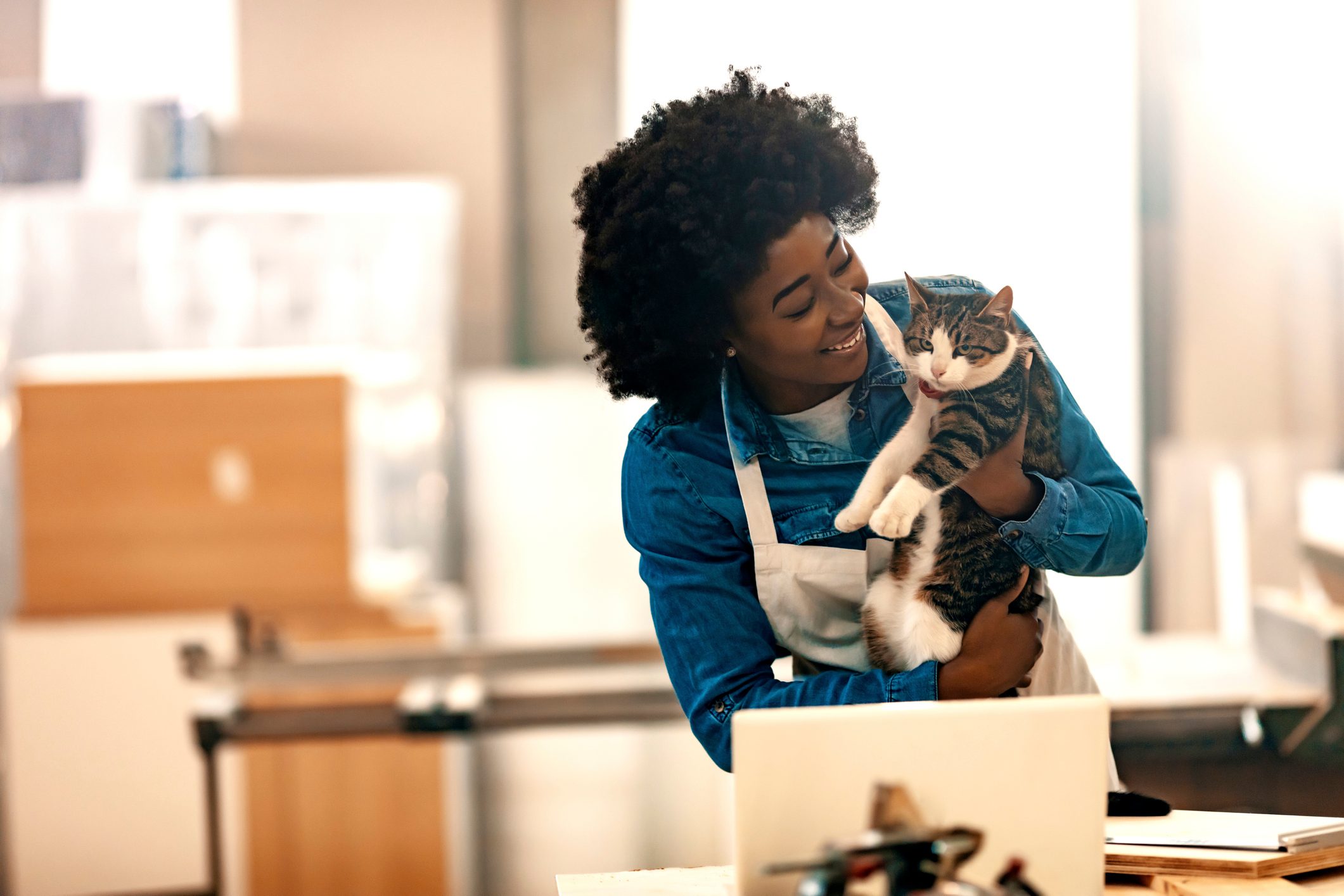 Smiling young woman with cat in workshop