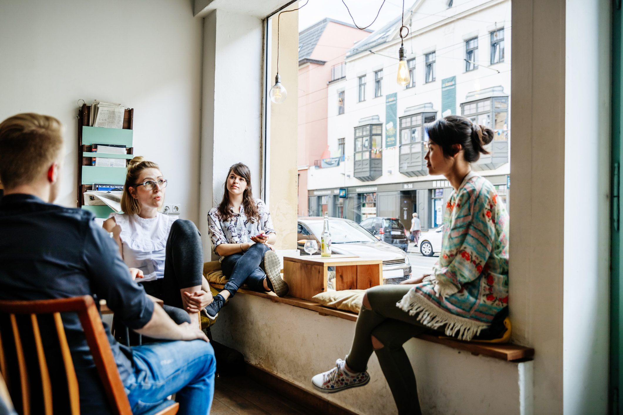 Group Of Friends Chatting and Relaxing Together In Cafe