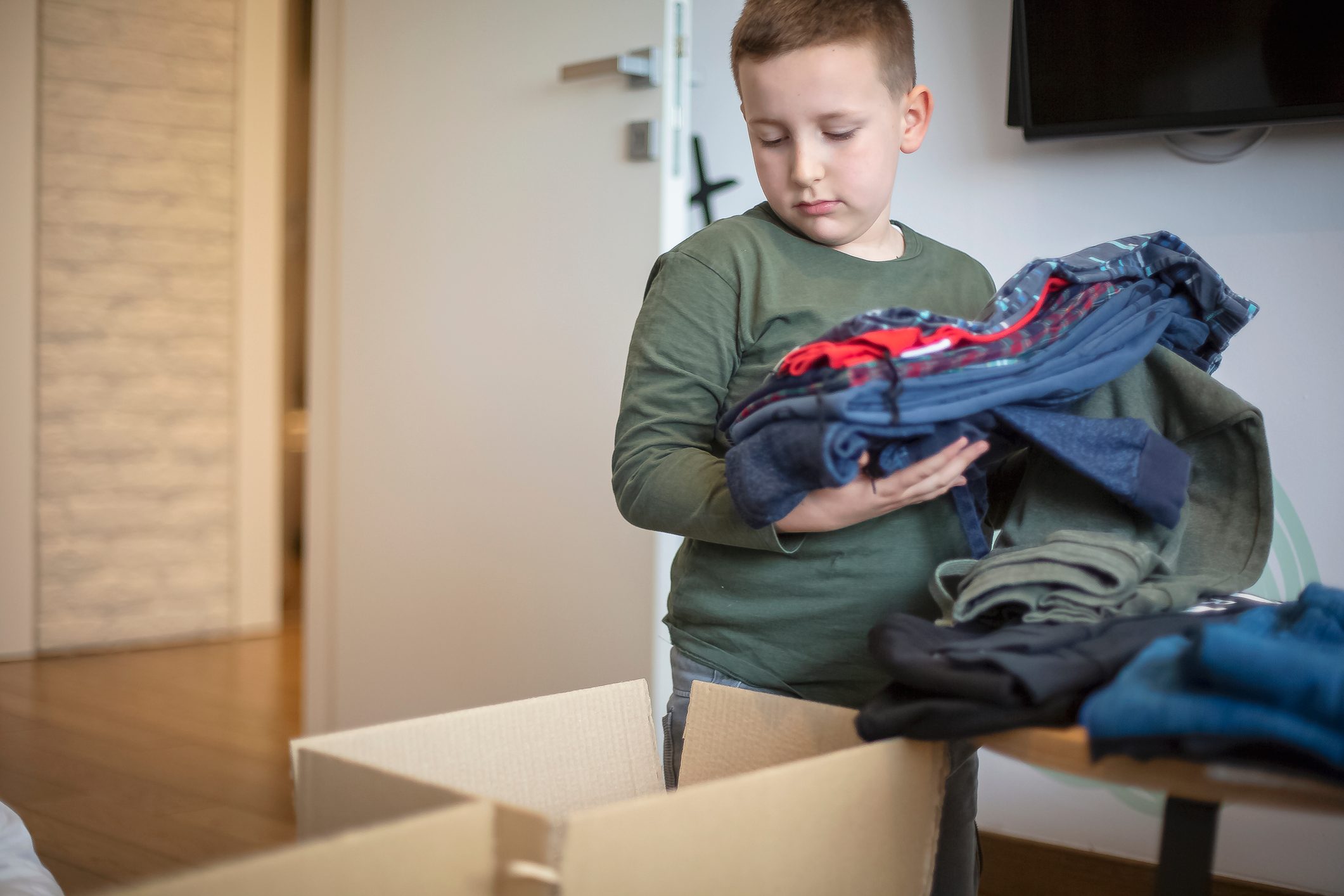 Children sorting clothes from their closet for donation