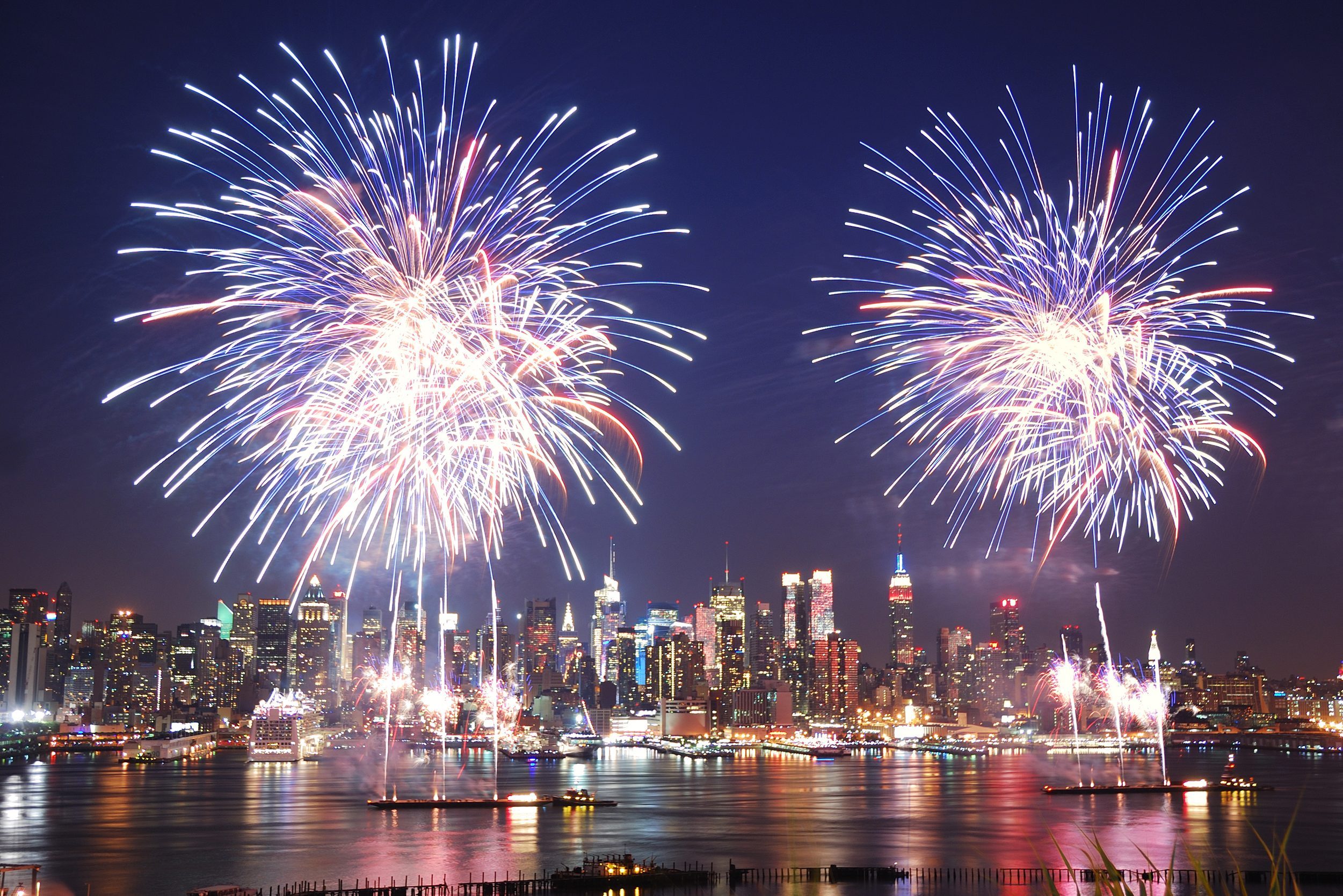 New York City Manhattan July 4th Independence day fireworks show with skyline over Hudson River viewed from New Jersey