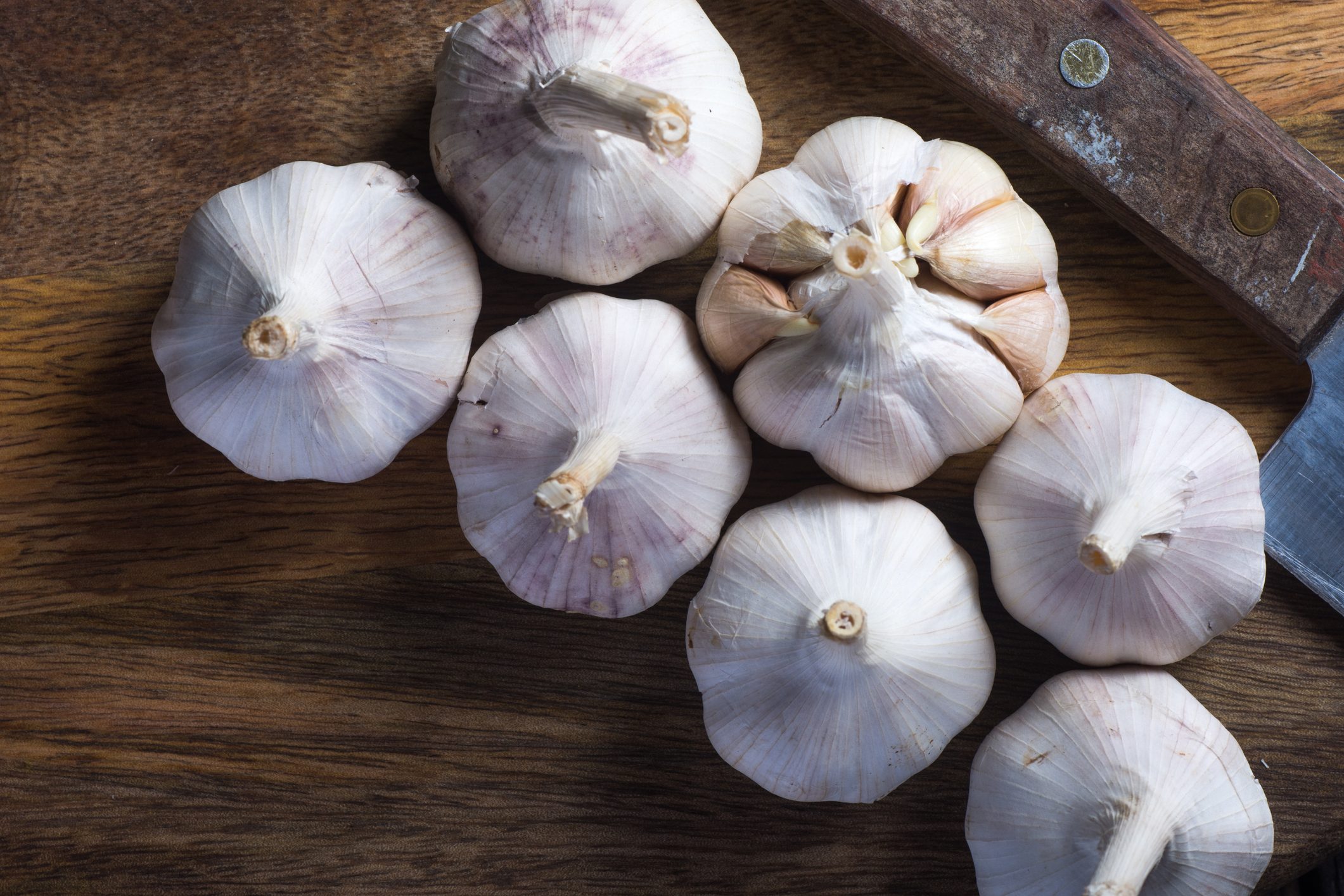 Garlic on wooden chopping board.