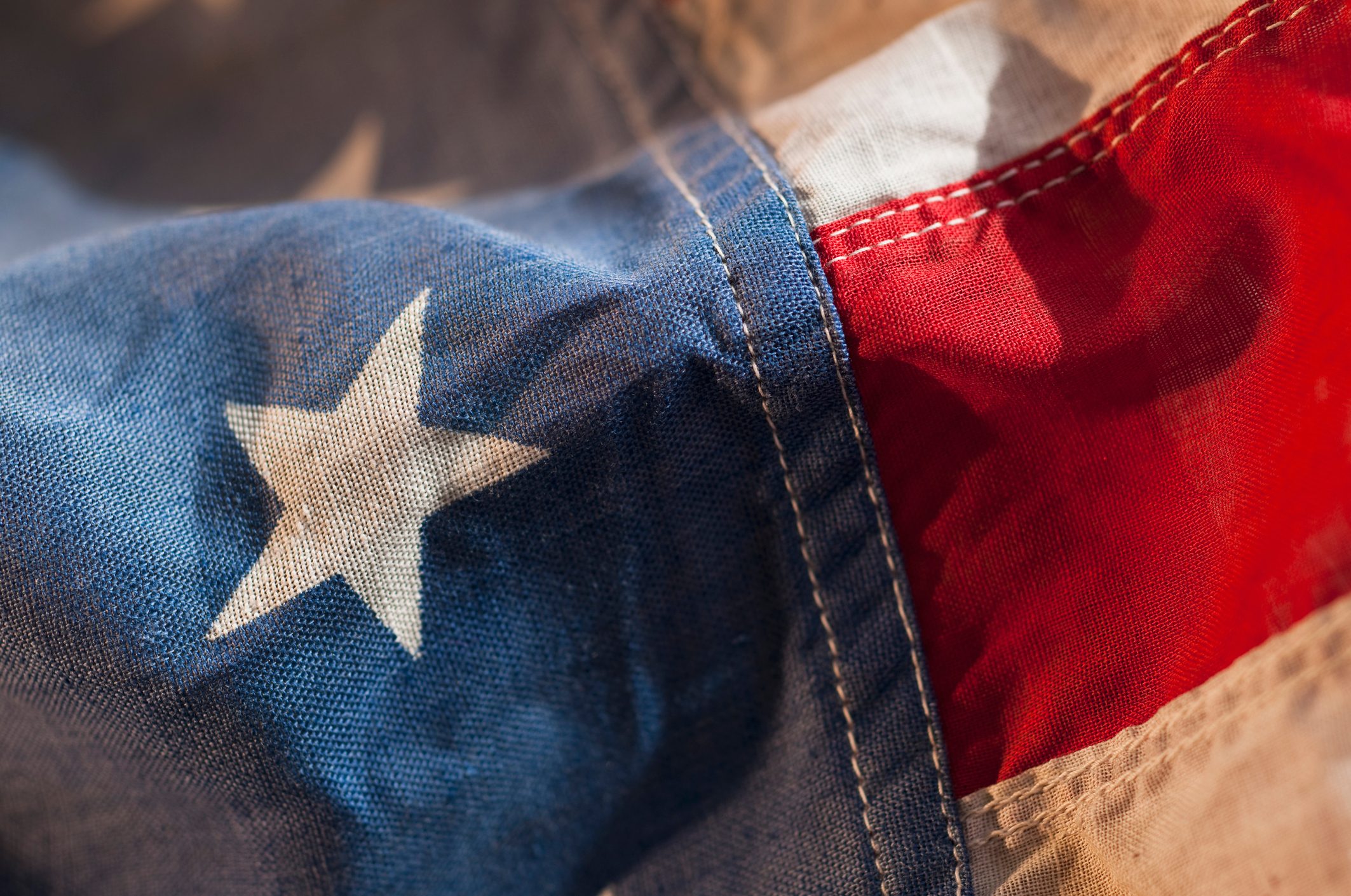Flag waves gently, showcasing blue with white stars and red stripes, suggesting close-up patriotic imagery.