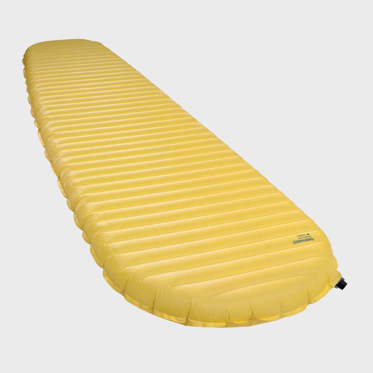 Yellow inflatable sleeping pad lies flat against a plain background.