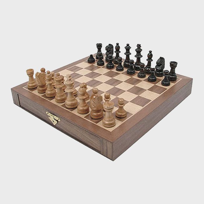 Wooden chessboard displays neatly arranged chess pieces, ready for play, in a simple and clear setup on a light background.