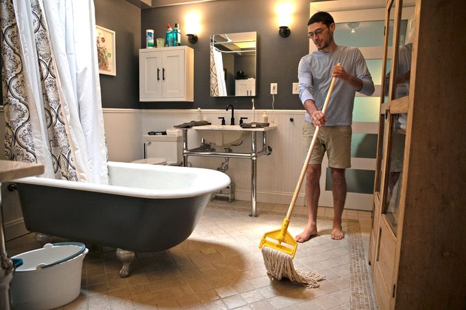 man moping bathroom floor