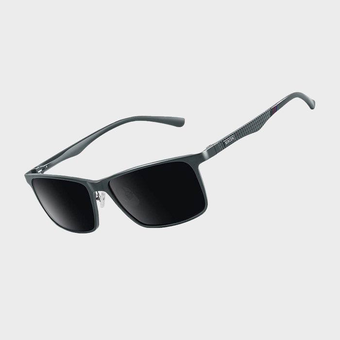 Sunglasses rest with dark lenses and metal frames, against a plain light gray background.