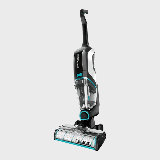 Vacuum cleaner stands upright, featuring a sleek black and white design with blue accents, labeled 