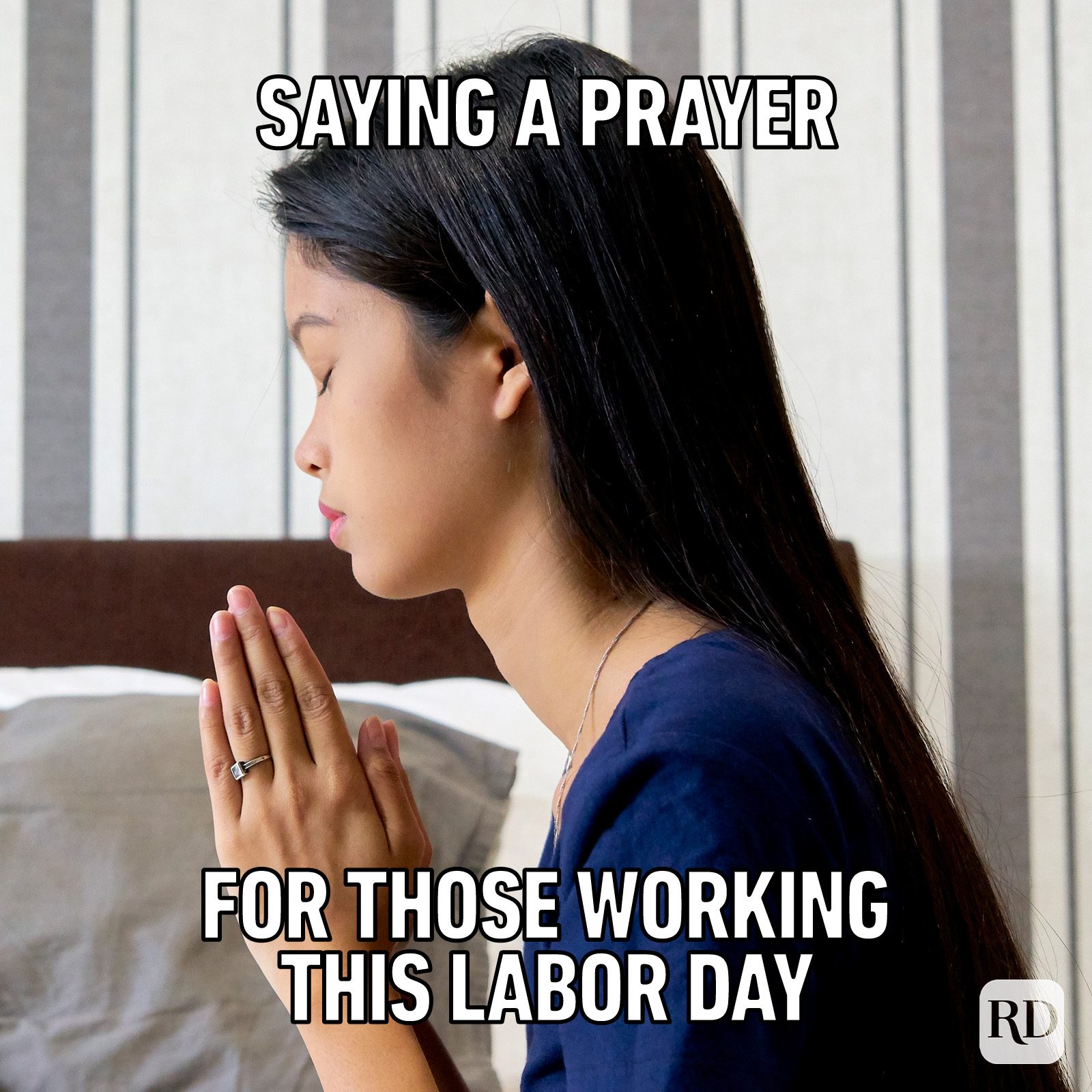 Person prays, hands clasped, indoors with striped backdrop. Text reads: "Saying a prayer for those working this Labor Day."