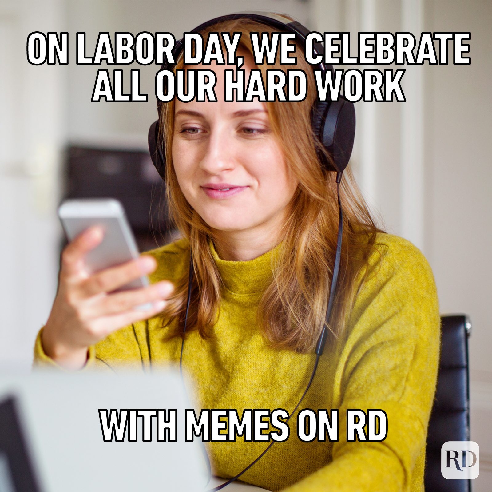 A woman wearing headphones looks at her phone, smiling in a cozy indoor setting. Text reads, "On Labor Day, we celebrate all our hard work with memes on RD."