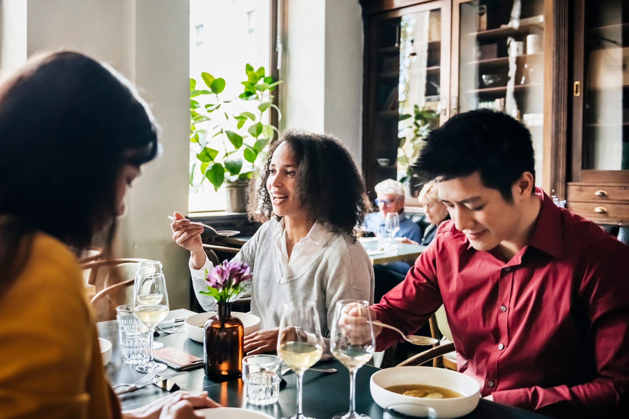 Group Of Friends Eating Lunch Together In Restaurant