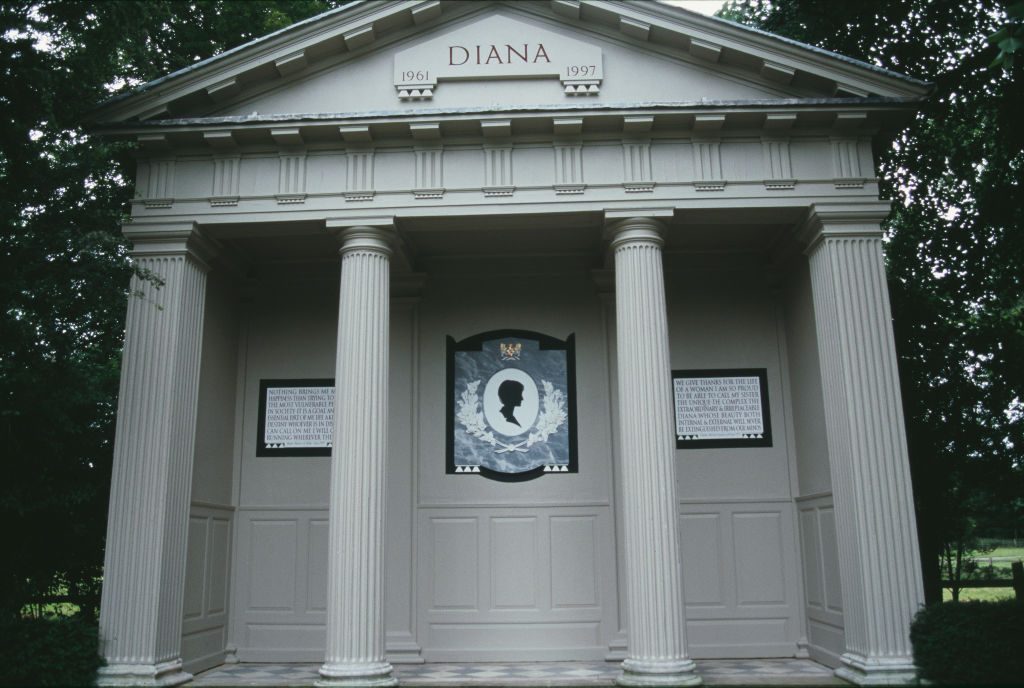 Portico features columns supporting a pediment labeled "DIANA 1961-1997," with two plaques and a silhouetted emblem, surrounded by trees.