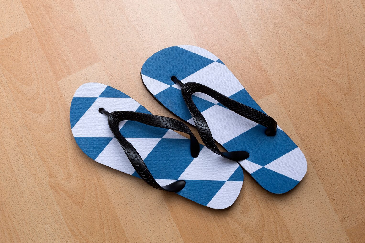 overhead view of a pair of flip flops on a wood floor