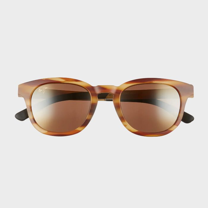 Tortoiseshell sunglasses with brown lenses rest on a white surface, logo inscribed on the upper left lens.