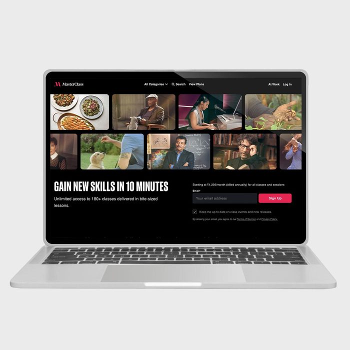 Laptop displays an educational website, featuring diverse video thumbnails. Text reads: 