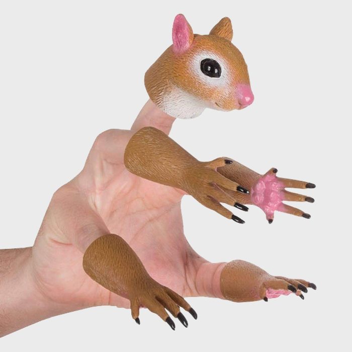 Hand wears squirrel hand puppets, animatedly posed against a plain white background, mimicking a lively squirrel character with realistic details.