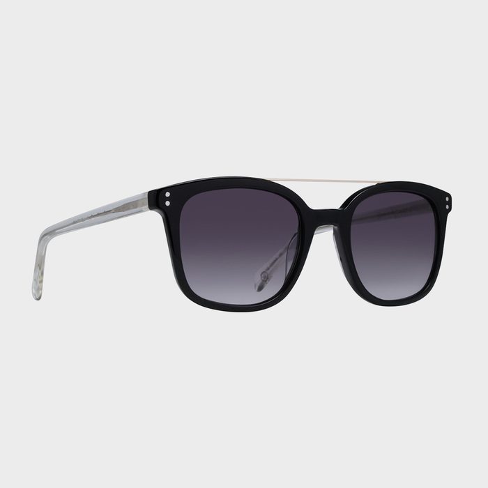Sunglasses resting; black frame with gradient lenses and transparent arms; isolated against a plain gray background.