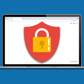 A laptop displays a red shield with a yellow padlock on its screen, set against a plain blue background.