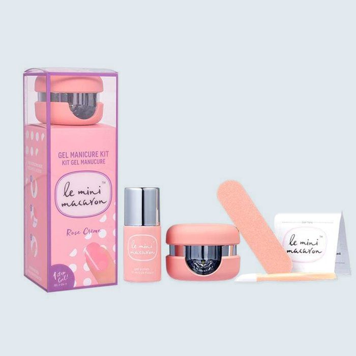 A pink manicure kit includes nail polish, LED lamp, nail file, and instructions box against a light background. Text: 