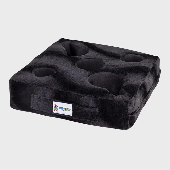 Black cushion holds cups with deep indentations, placed in a plain light gray background. A label reads, 