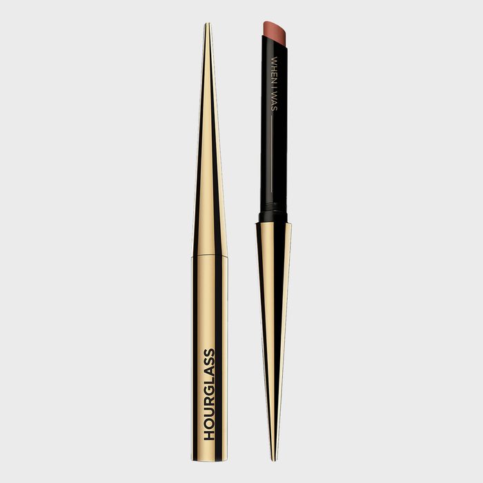 Lipstick reveals a brown shade, surrounded by gold and black casing. Text reads 