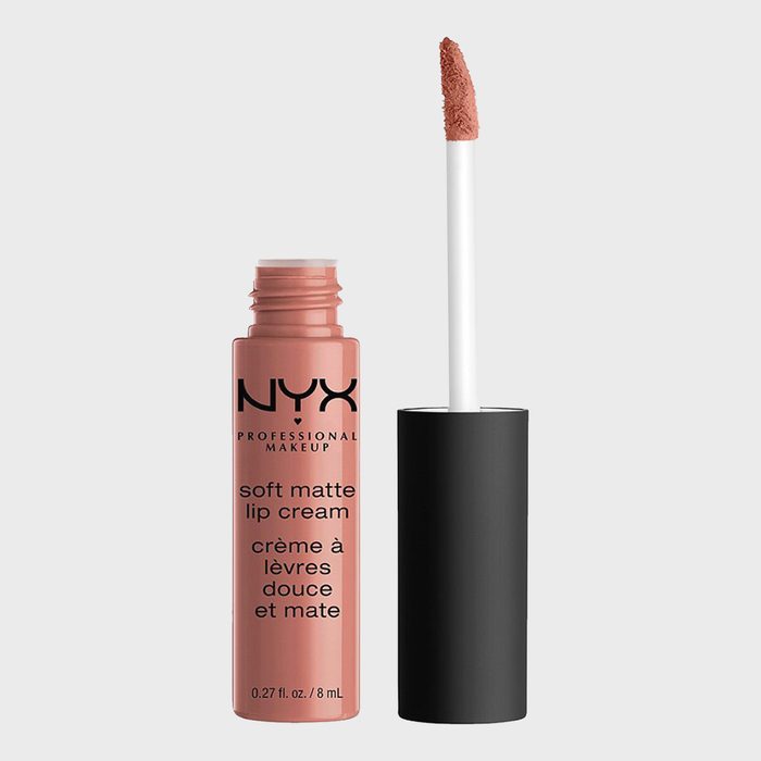 Lip cream stands open, applicator leaning beside, against a plain background. Text on container: 