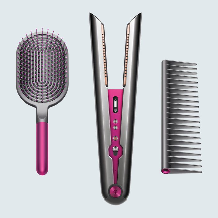 Hairbrush, straightener, and comb are arranged vertically; metallic and pink colors emphasize design on a light gray background.