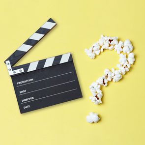 Clapperboard lies open; popcorn forms a question mark on a yellow background. Clapperboard sections: 